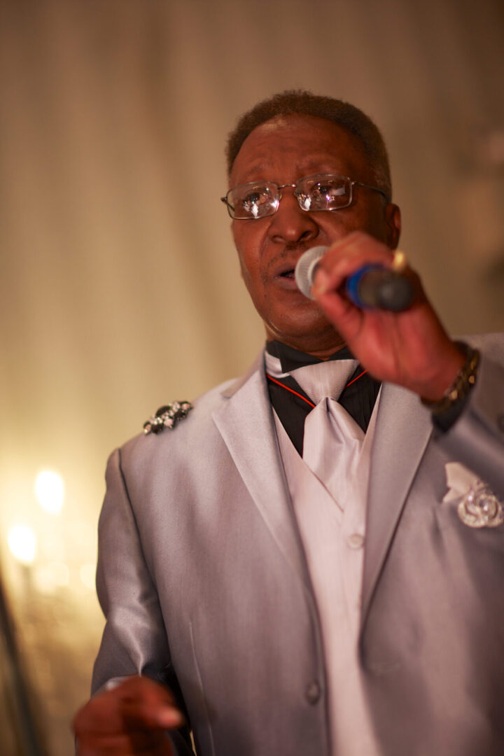 A man in a suit and tie holding a microphone.