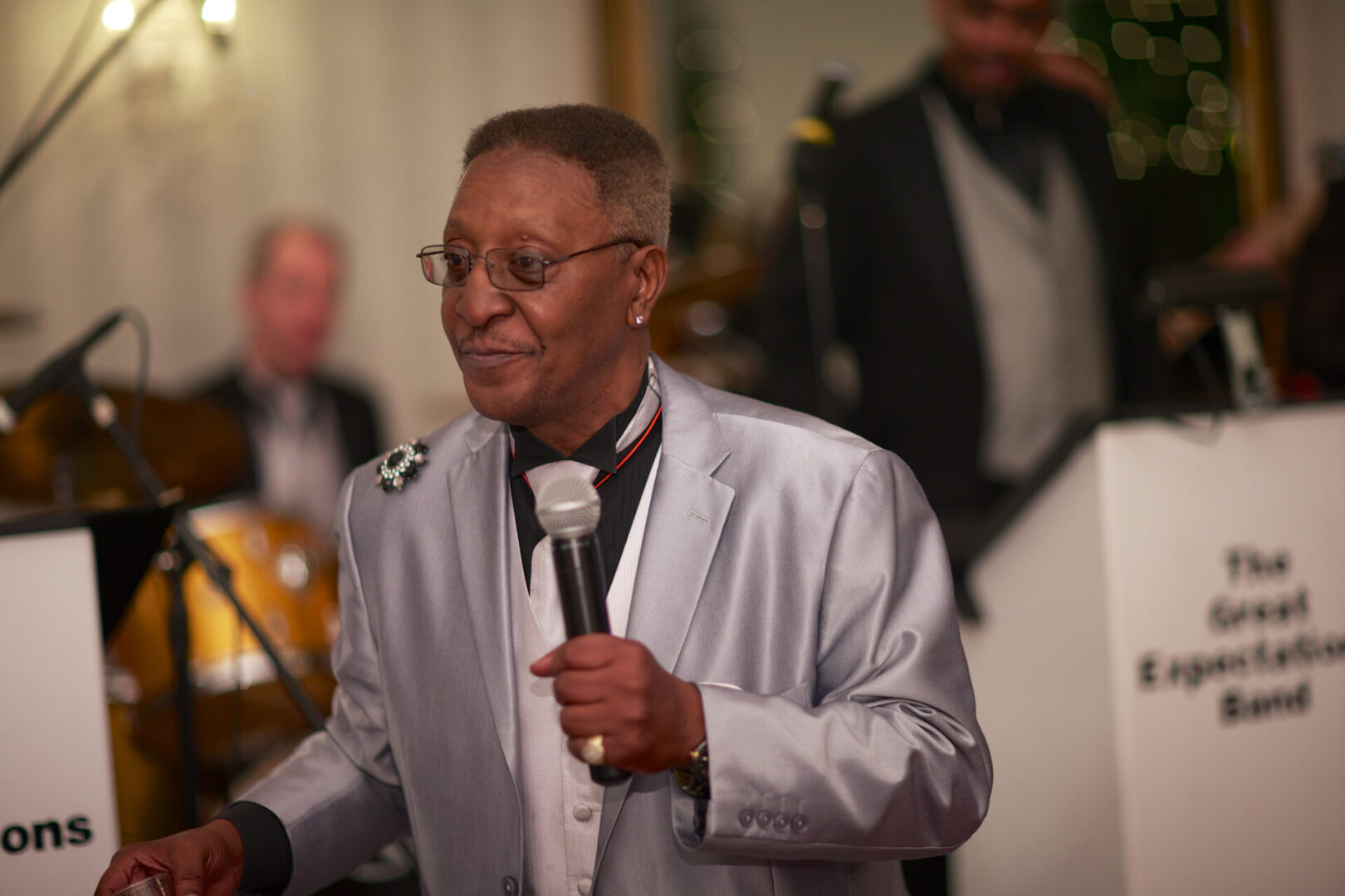 A man in a silver suit holding a microphone.