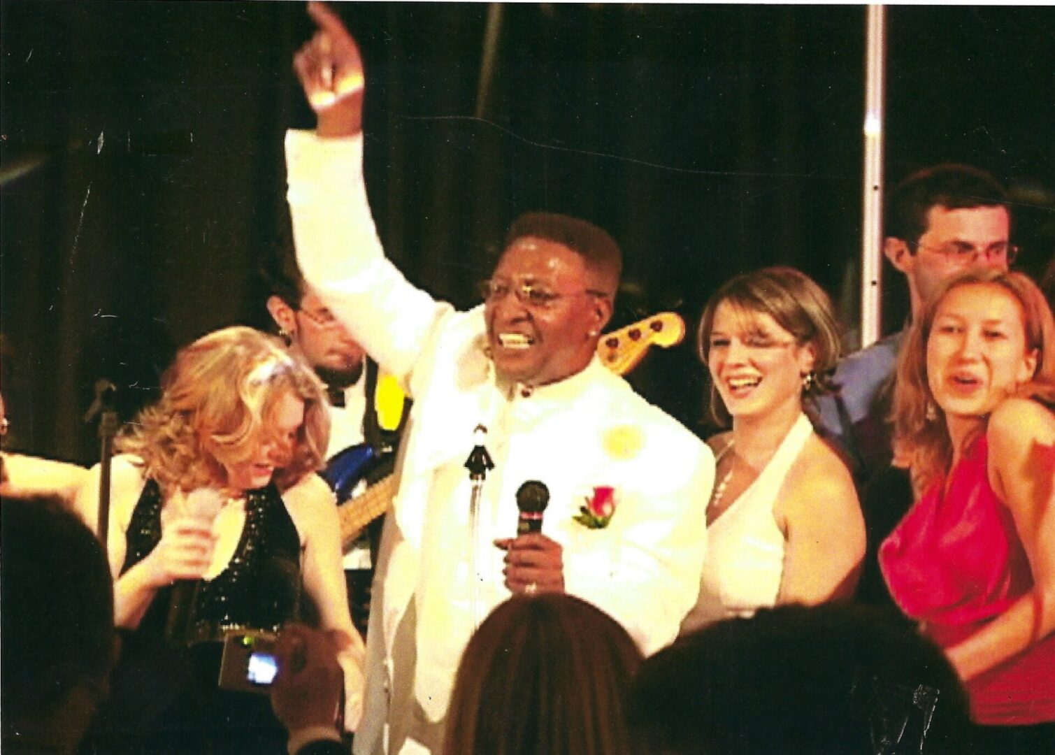 A man in white jacket holding up his hand.